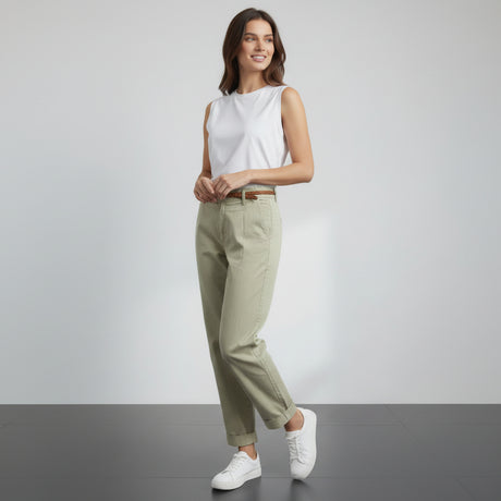 Person wearing olive green pants and white sneakers on a gray floor with white background