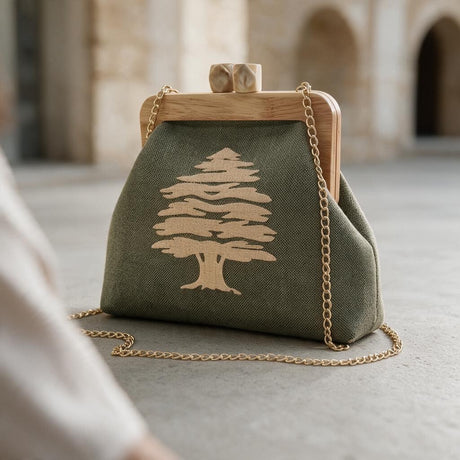 Olive green cedar embroidered clutch with a wooden clasp frame and long gold chain under stone arches