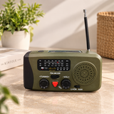 Olive green AM FM SW radio with a telescopic antenna and solar panel on a marble counter