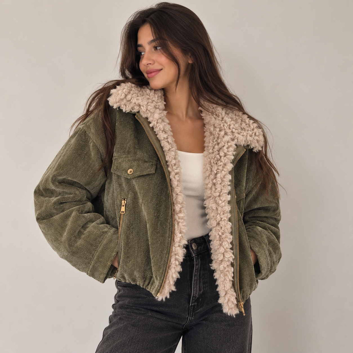Olive herringbone jacket with fluffy cream sherpa collar worn over a white tank top