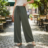 Person wearing olive green wide-leg pants in an outdoor setting