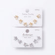 Opal petal stud earrings with cubic zirconia wings shown on gold and silver cards