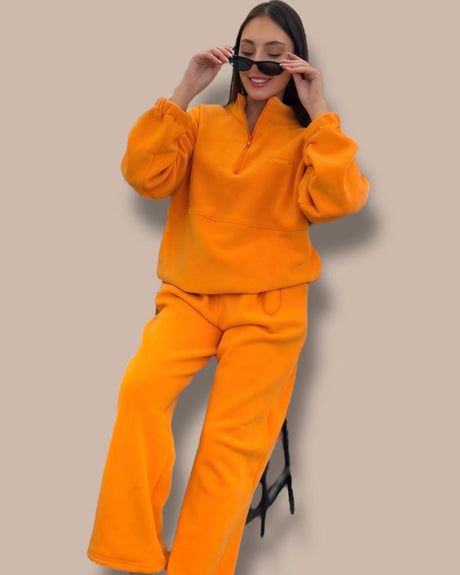 Person wearing an orange outfit against a beige background