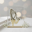Clasped hands and a rosary in frosted acrylic beside etched Armenian script