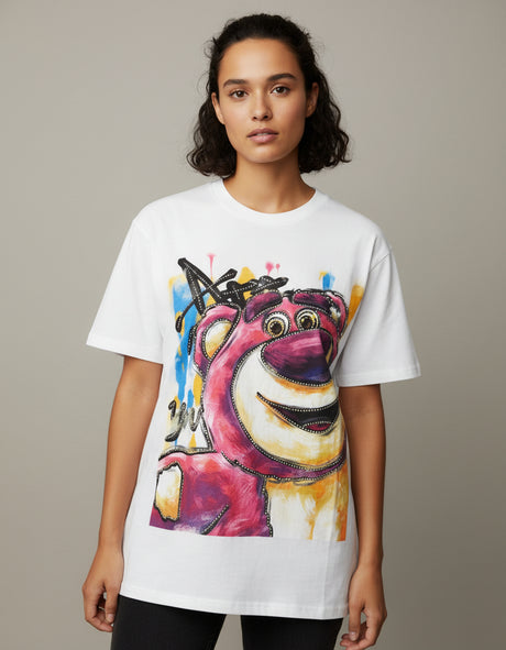 Person wearing a white tshirt with a colorful graphic design of a bear on a plain background