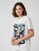 Woman wearing a white tshirt with a graphic design of a bugs bunny on a plain background