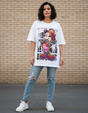 Person wearing a white graphic tshirt of Mickey Mouse and ripped jeans standing against a brick wall