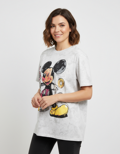 Woman wearing a white tshirt with a cartoon character design on a plain background