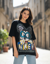 Woman wearing a black tshirt with a colorful graphic design in an urban setting