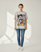 Person wearing a gray oversized tshirt with a Mickey Mouse graphic design on a white background