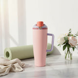 Blush pink insulated travel tumbler with a coral flip cap on a marble counter