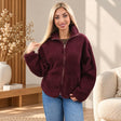 Woman in a pastel pink, baby blue and cream plaid sherpa zip jacket with a fluffy collar