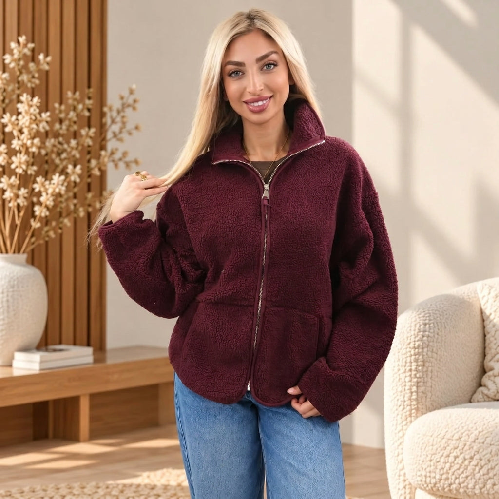 Woman in a pastel pink, baby blue and cream plaid sherpa zip jacket with a fluffy collar