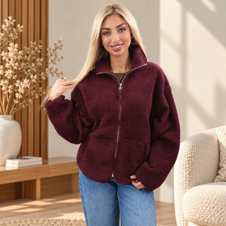 Woman in a pastel pink, baby blue and cream plaid sherpa zip jacket with a fluffy collar