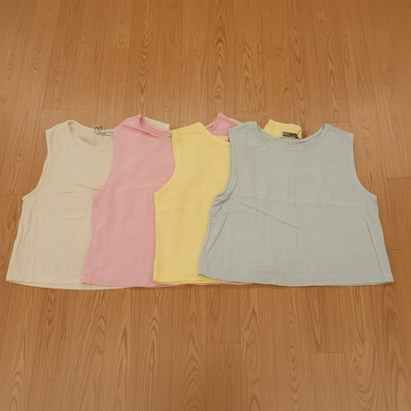 Stack of colorful tank tops on a wooden surface
