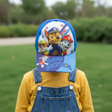 Blue and white cap with three rescue pups, worn by a child in denim overalls