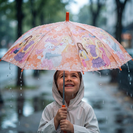 Girl in a hooded raincoat smiling under a peach umbrella printed with dolls and puppies