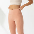 Person wearing peach leggings on a white background