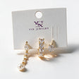 Three gold single earrings on a card with a crystal pearl drop, a baguette crystal huggie and a round stud