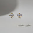 Pair of earrings with pearl-like centers on a light grey background