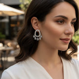Silver pearl oval earring with dangling square crystals worn