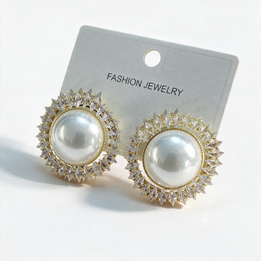 Gold pearl stud earrings ringed with clear crystal points on a white card