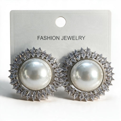 Pair of silver tone pearl sunburst earrings with marquise crystals on a white display card