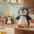 Penguin plush wearing bright green headphones