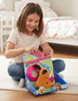 Open salon box with a plush puppy, a magenta grooming cape, toy scissors and a comb