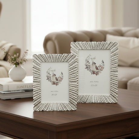 The same fluted frame design in antiqued ivory, standing on a dark walnut surface