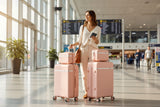 Traveller with pink suitcases and vanity cases in an airport terminal