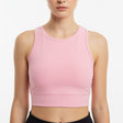 Woman wearing a pink crop top against a white background