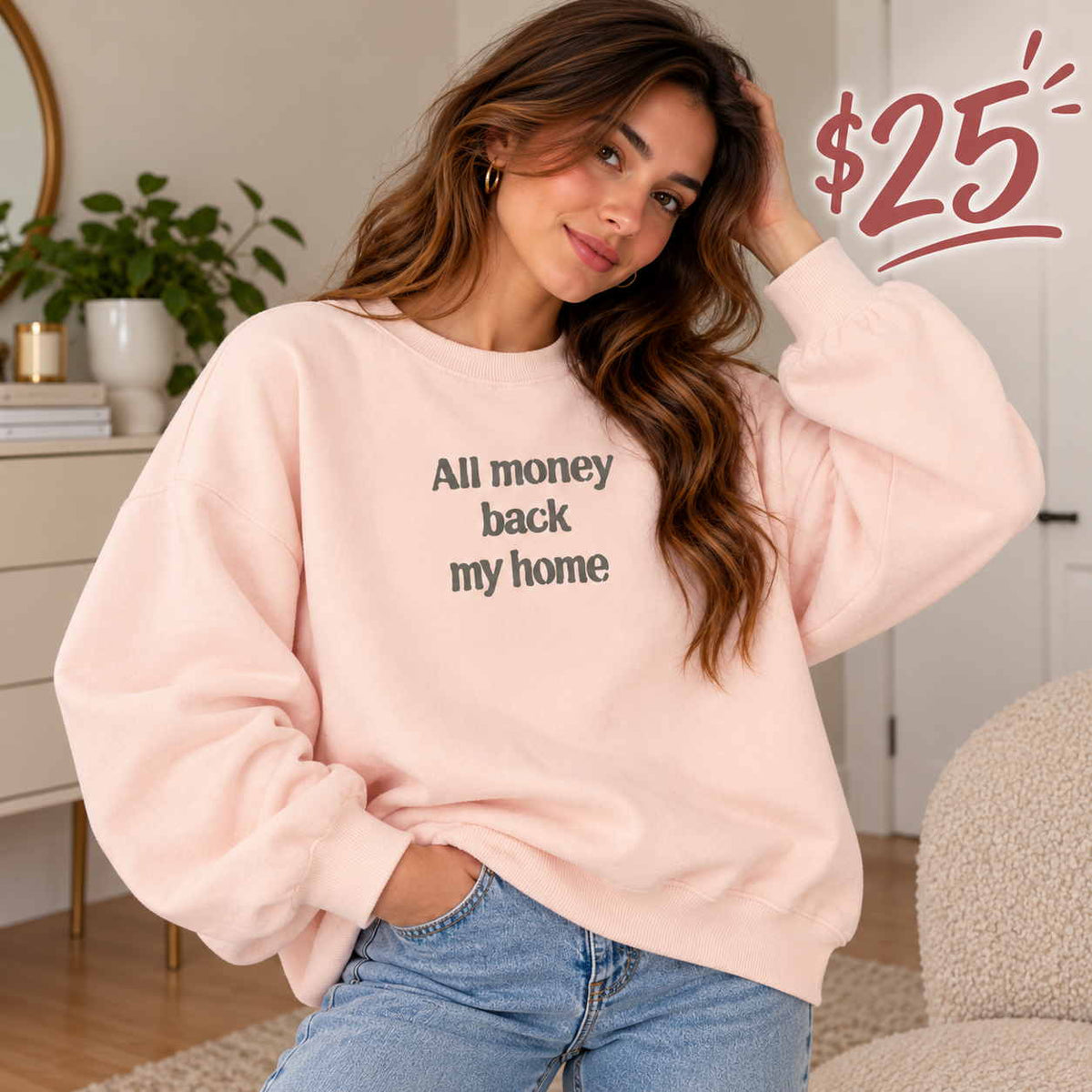 Woman in a pink sweatshirt with an All Money Back My Home slogan print and light blue jeans