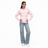 Pink and cream wide striped wool sweater worn with jeans and sneakers, full length