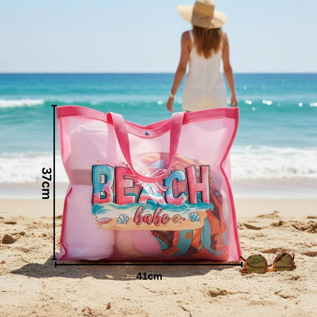 Pink beach bag with 'Beach Babe' text on a sandy beach with ocean view