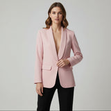 Woman wearing a pink blazer against a plain background
