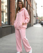 Person wearing a pink bonnie club jogging set on a city street