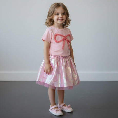 Pink bow tee with iridescent tulle skirt worn in a garden