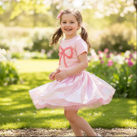 Girl in a pink ruffle bow tee and a shimmering tulle skirt