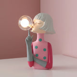 Soft pink dress with teal spots, silver bob and one finger raised beside a lit globe