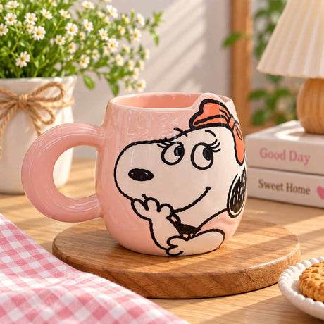 Cartoon dog with an orange bow hand drawn on a soft pink mug, chunky ring handle