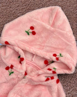 Close up of the soft hood and red embroidered cherries on pink fleece