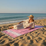 Woman sitting on a colorful towel at the beach