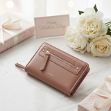 Pink wallet on a light surface with white roses and a 'Happy Mother's Day' card