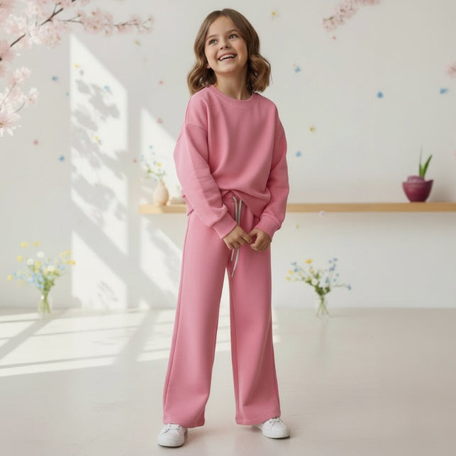 Girl in a pink sweatshirt and matching wide leg jogging pants
