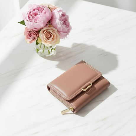 Pink leather wallet on a white surface with pink roses in the background