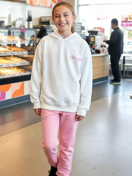 Girl in a cream oversized hoodie and soft pink joggers