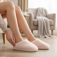 Pale pink plush slip on slippers with white cushioned sole and closed toe