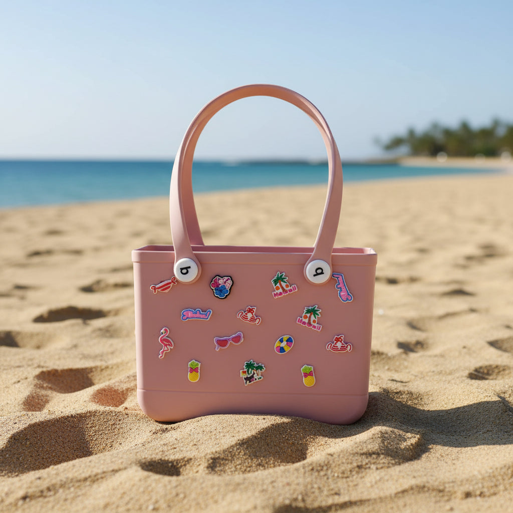 Pink crocs bag with decorative stickers on the sand