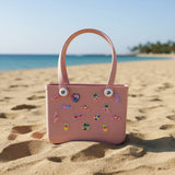 Pink crocs bag with decorative stickers on the sand